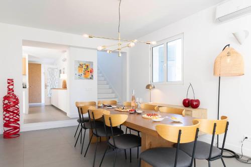 une salle à manger avec une table et des chaises en bois dans l'établissement Villa Acacias - Au coeur de Saint-Tropez, à Saint-Tropez