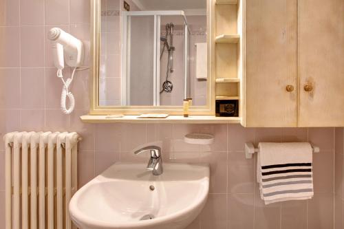 W łazience znajduje się umywalka i lustro. w obiekcie Appartamenti Elisabetta n2 w Livigno