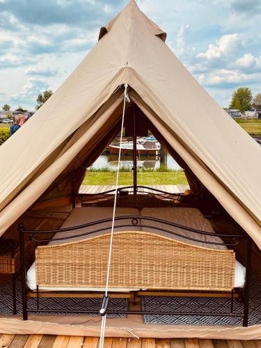 - un kiosque avec un banc à l'intérieur dans l'établissement Bell Tent aan de haven, à Heerewaarden