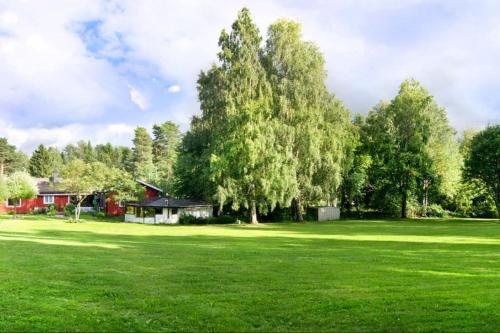 un grande campo verde con una casa e un albero di Nice Entire Semi - Attached House - M a Umeå
