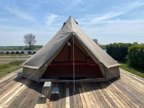 a canvas tent sitting on a wooden deck at Bell Tent aan de haven in Heerewaarden