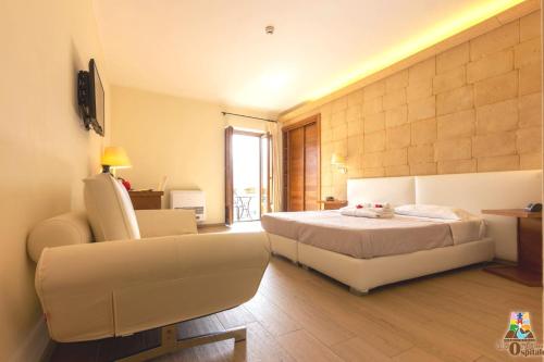 a bedroom with a bed and a couch and a chair at Il Borgo Ospitale - Albergo Diffuso in Rotonda