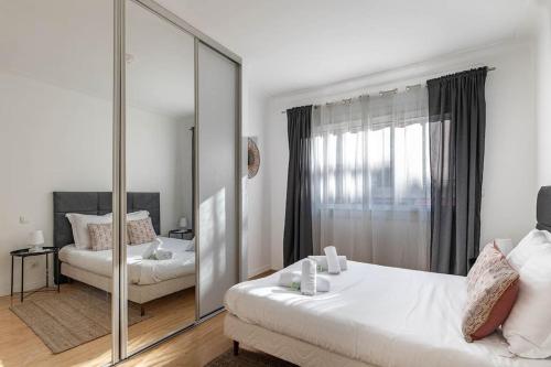 - une chambre blanche avec un miroir et un lit dans l'établissement Charmant Appartement à 300 mètres des plages de la Croisette, à Cannes
