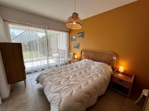 une chambre avec un grand lit et une grande fenêtre dans l'établissement Appartement 3 pièces rénové, proche plage et côte sauvage avec jardin et parking - Quiberon - FR-1-478-252, à Quiberon