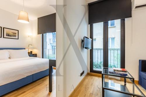 a bedroom with a bed and a tv and windows at X Flats in Istanbul