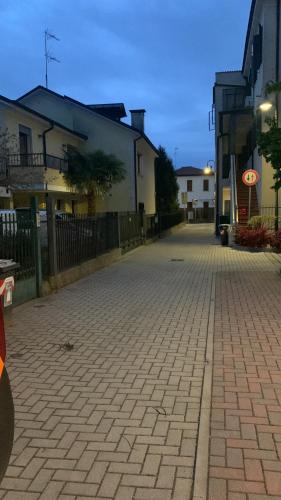 a brick street with buildings and a fence at Alloggio M&M in Padova