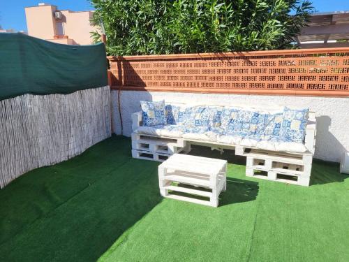 a patio with a couch and a bench on the grass at Casamarina Orchidea in Campomarino