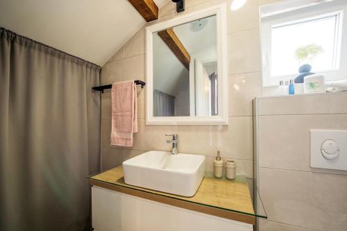 a bathroom with a sink and a mirror at Apartman I & J in Imotski