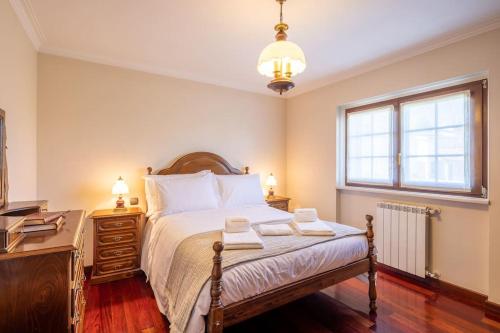 um quarto com uma cama, uma cómoda e uma janela em casabraga.207 - Villa with Pool Bom Jesus em Braga