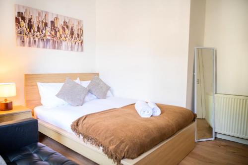 a bedroom with a bed with two towels on it at Purple Blossom, 2 bed apartment, Wi-Fi, near Didsbury, free parking in Manchester