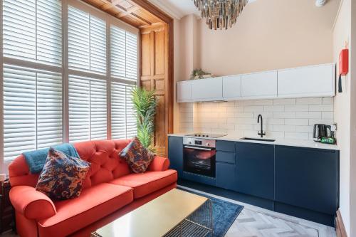 a living room with a red couch in a kitchen at The Governance Apartments in Windermere