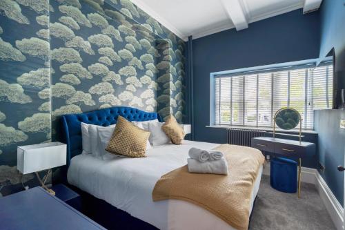 a bedroom with a bed with a blue wall at The Governance Apartments in Windermere