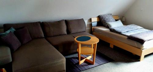 a living room with a brown couch and a stool at Schöne Doppelzimmer in Rheine