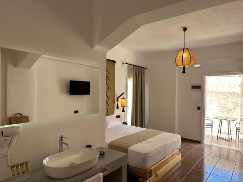 a bedroom with a bed and a sink and a bathroom at Armeno Resort in Marathias