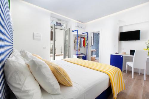 a white bedroom with a bed and a desk at YourHome - Relais Loggia Li Galli in Massa Lubrense