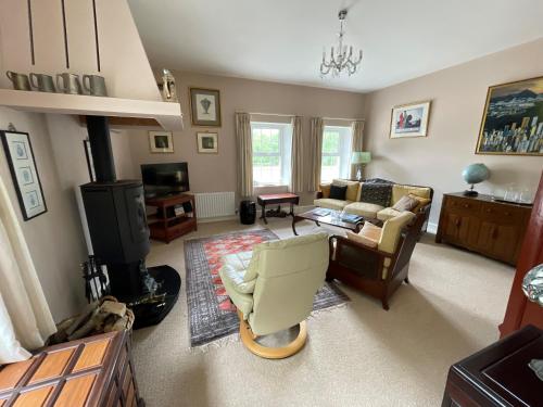 a living room with a couch and a chair at The Cottage at Riverbank in Ballinamallard