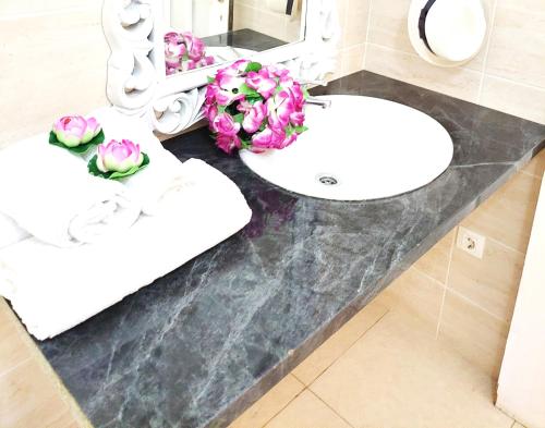 a bathroom with a sink and flowers on a counter at Adeje House 2 bedrooms, Wifi Free in Adeje