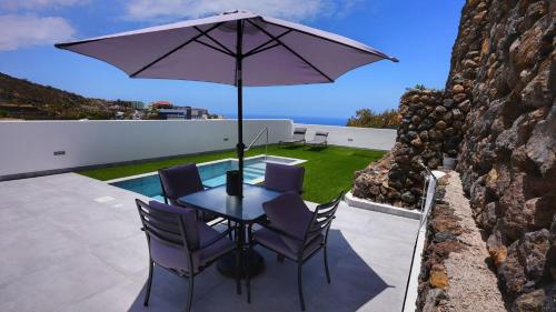 einen Tisch mit Stühlen und einem Sonnenschirm auf einer Terrasse in der Unterkunft Mireya home in Icod de los Vinos