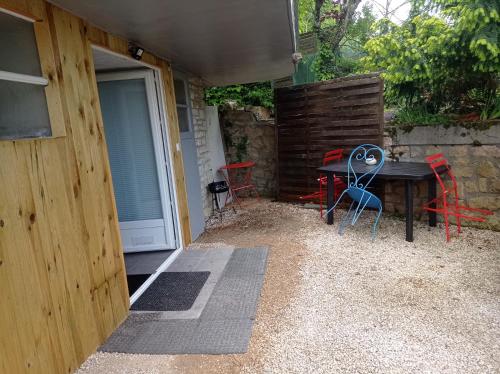 an open door to a patio with a table and chairs at appartement rez de chausse in Gourdon-en-quercy