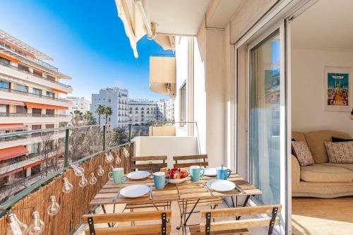 - une table sur un balcon avec vue sur la ville dans l'établissement Charmant Appartement à 300 mètres des plages de la Croisette, à Cannes