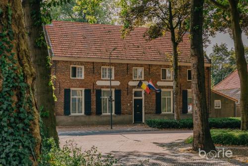 a brick building with a flag in front of it at Hotel Brasserie Den Engel in Baarle-Nassau