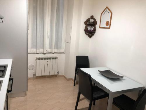 uma sala de jantar com uma mesa branca e cadeiras em Manarola apartament em La Spezia