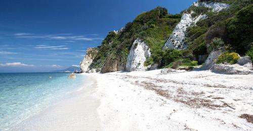 a beach with white sand and the ocean at Ibiscus Beach Village in Follonica
