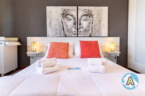 a bedroom with a large white bed with red pillows at Moderno appartamento a Montesilvano 54a in Montesilvano