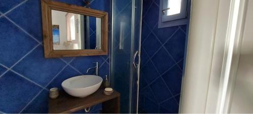 a blue bathroom with a sink and a mirror at L' Atelier, Marpissa Paros in Márpissa