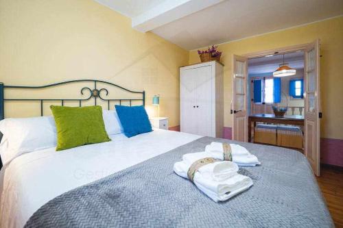 una camera da letto con un grande letto con asciugamani di Casa PedroArias Rodiles a Villaviciosa