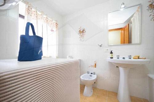 y baño con bañera blanca, lavamanos y bolsa. en Casa PedroArias Rodiles, en Villaviciosa