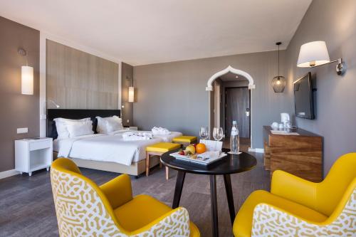une chambre d'hôtel avec un lit, une table et des chaises dans l'établissement AP Oriental Beach - Adults Friendly, à Portimão