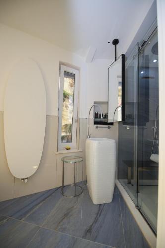 a white kitchen with a table and a window at Oldwell Hotel in Santa Domenica