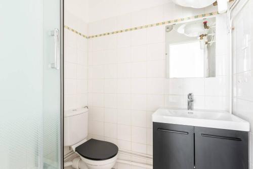 a bathroom with a toilet and a sink and a mirror at Apartment next Tour Montparnasse - Sable in Paris