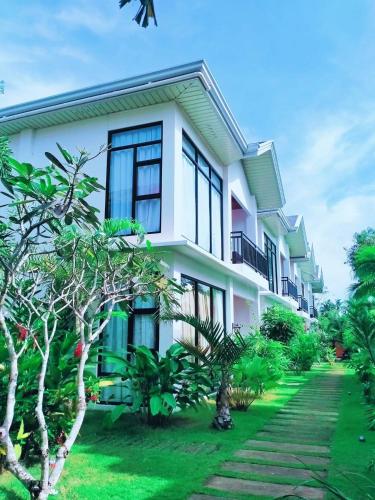a white building with black windows and a yard at Tana Mysterious garden in Panglao