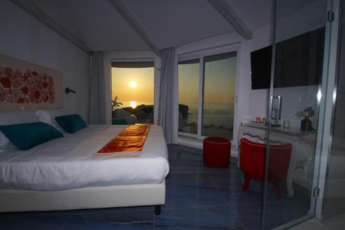 a bedroom with a bed and a view of the ocean at Oldwell Hotel in Santa Domenica
