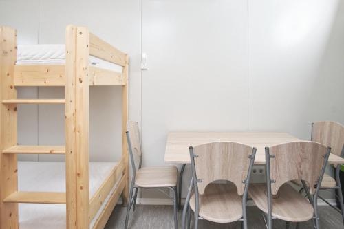 a room with a table and chairs and a bunk bed at Hostel Industrial in Čakovec