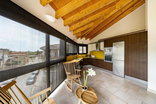 a kitchen with wooden ceilings and a large window at Apartaments Tee & Sea in Santa Cristina d'Aro