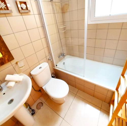 a bathroom with a toilet and a sink and a tub at SMALL APARTMENT, Adeje House Wifi Free in Adeje