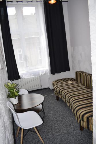 sala de estar con mesa, sillas y ventana en Apartamenty Rynek X en Przemyśl