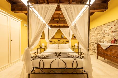 una camera con letto a baldacchino e tende bianche di Dimore Candriano - Irpinia a Torella deʼ Lombardi