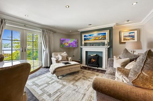 a living room with two couches and a fireplace at Skyfall Glencoe at Creag an-t Sionnaich in Glencoe