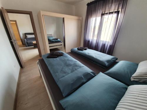 una camera con due letti e uno specchio di Apartmani Bozic-Tokic a Krk
