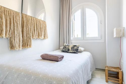 塞維利亞的住宿－La casa de Jacobo，白色的客房设有一张带窗户的床