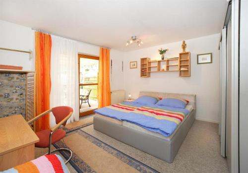 1 dormitorio con cama, escritorio y silla en An der Seeve, Ferienhaus, en Jesteburg
