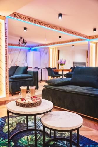 a living room with two tables and a couch at GORSKI RESORT Lux Apartments Jacuzzi & Sauna in Poronin