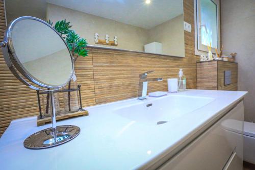 a bathroom with a large mirror on a sink at LITORAL COSTA DORADA - VILLA MONET Only families in Cambrils