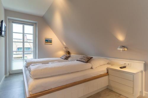 Duas camas num quarto com uma janela em Reetdachhaus Kleine Krabbe Reetdachhaus Kleine Krabbe em Ording