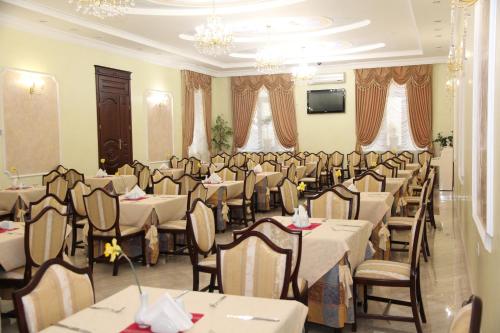 a restaurant with tables and chairs in a room at Kleopatra VIP hotel in Kamianets-Podilskyi