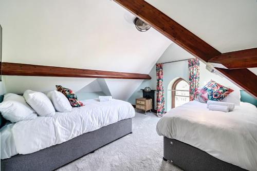 two beds in a attic room with wooden beams at The Governance Apartments in Windermere